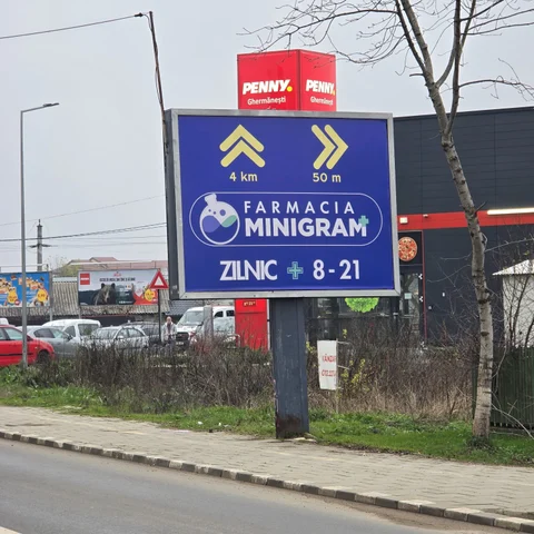 Panou backlit pentru retea farmacii cu sageti directionale 4 km si 50 m, montat la intrare in Snagov langa supermarket — campanie OOH derulata de Mora Group