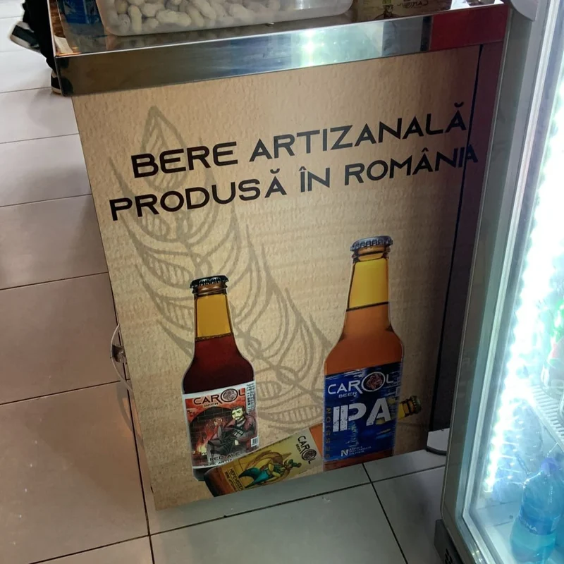 Colantare laterala frigider comercial cu mesaj "BERE ARTIZANALA PRODUSA IN ROMANIA" si 2 sticle bere artizanala originala si bere artizanala IPA — aplicare vinil autoadeziv pe metal inox cu finisaj uniform fara bule de aer