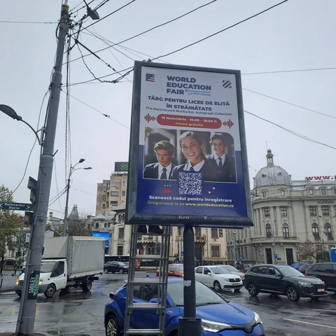 Citylight Mora Group cu campanie World Education Fair targ pentru licee de elita in strainatate, montat in Piata Romana cu cladirea Academia de Studii Economice (cupola si fatada www.ase.ro) in fundal si indicator Bulevardul Dacia