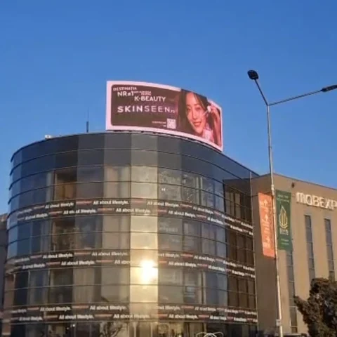 Panou digital LED pe acoperis pe cladire glass curbata in intersectia Sos. Fabrica de Glucoza cu Petricani, Sector 2 Bucuresti — campanie cosmetice ingrijire ten client cosmetice ten derulata pe panou Mora Group cu vizibilitate clara catre traficul auto si pietonal local
