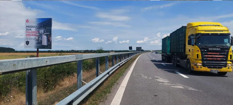 Panou publicitar mare format 14x14 m Mora Group pe Autostrada A3 Bucuresti-Ploiesti — unipol care domina campul vizual langa un camion articulat in trafic, dovada de scara pentru dimensiunea panoului