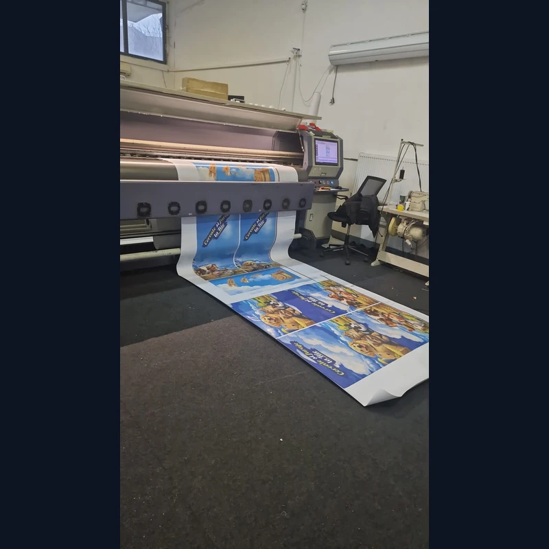 Productie window graphics Cereale si furaje la Ilie in atelierul Mora Group — imprimanta industriala large-format printeaza pe rola material PVC perforat one-way vision cu grafica brand: animale de ferma, lan de grau si banner Cereale si furaje la Ilie pentru ferestrele magazinului