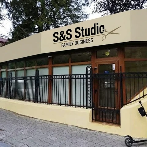 Banner publicitar client salon barbershop montat pe fatada salonului — 14 metri latime cu logo si foarfeca, design grafic, productie si montaj realizate complet de Mora Group