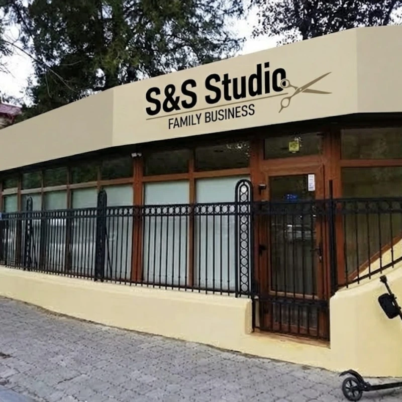 Banner publicitar client salon barbershop montat pe fatada salonului — 14 metri latime cu logo si foarfeca, design grafic, productie si montaj realizate complet de Mora Group