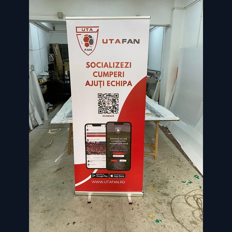 Roll-up publicitar 85x200 cm produs de Mora Group — banner PVC printat full color in alb si rosu cu logo club sport, cod QR si screenshot-uri aplicatie mobila, structura aluminiu pentru evenimente