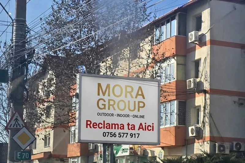 Panou publicitar Mora Group pe Soseaua Alexandriei DN6/E70 in Bragadiru — billboard alb cu logo gold si text Reclama ta Aici 0756 577 917, vizibil de la artera principala